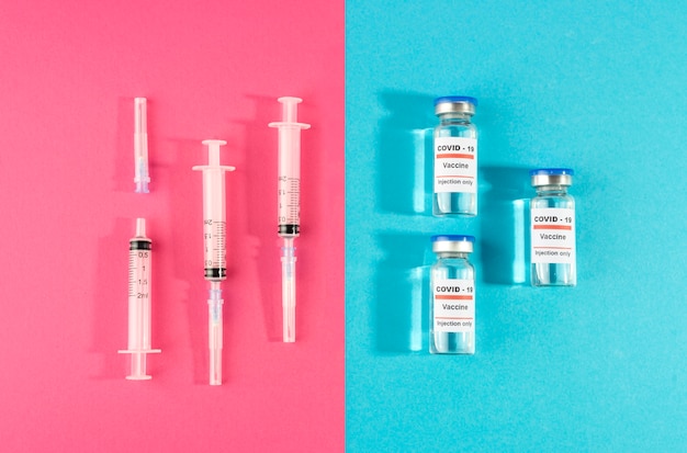Bezpłatne zdjęcie płaskie fiolki ze szczepionkami i strzykawki