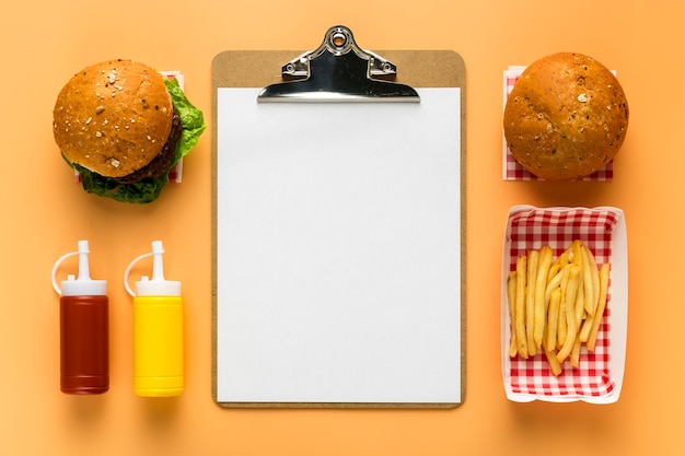 Bezpłatne zdjęcie płaskie ukształtowanie pustego menu z frytkami i burgerem