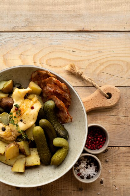 Płaskie ułożenie naczynia do raclette ze składnikami i pysznym jedzeniem
