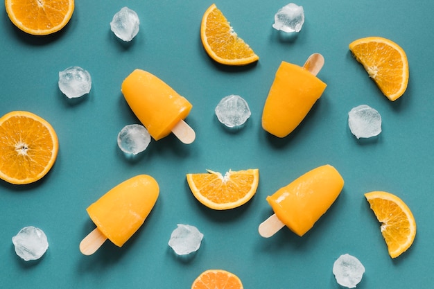 Bezpłatne zdjęcie płaskie ułożenie pysznych popsicles z lodem i pomarańczą