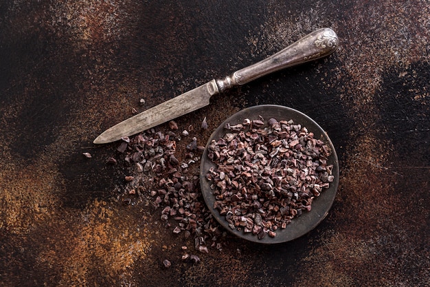 Płasko położyć zmielone ziarna kakaowe na talerzu z nożem