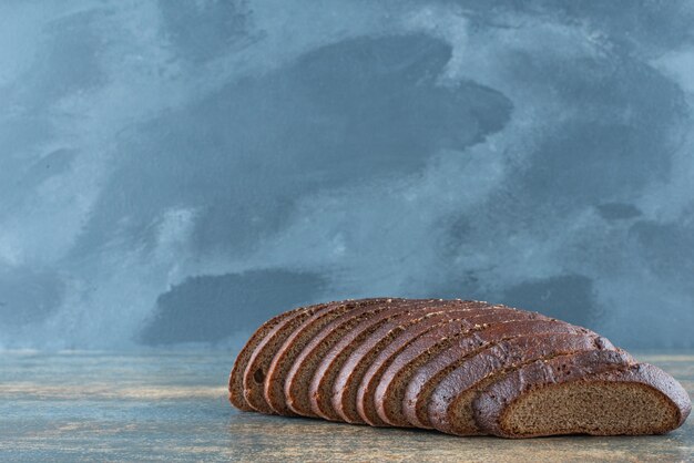 Plasterki ciemnego chleba na tle marmuru