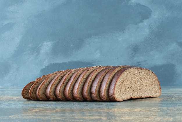 Plasterki ciemnego chleba na tle marmuru