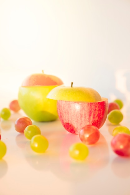 Bezpłatne zdjęcie plasterki czerwone i zielone jabłko z winogron na białym tle