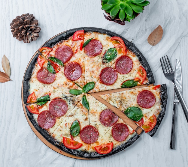 Bezpłatne zdjęcie plasterki pizzy pepperoni na stole