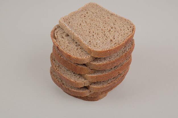 Plasterki świeżego ciemnego chleba na białym tle. Wysokiej jakości zdjęcie