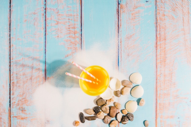 Bezpłatne zdjęcie plażowy pojęcie z soku szkłem na drewnianej desce
