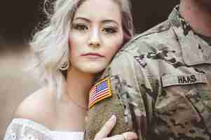 Bezpłatne zdjęcie płytkie fokus atrakcyjnej kobiety trzymającej ramię amerykańskiego żołnierza