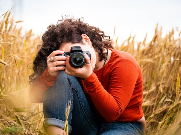 Bezpłatne zdjęcie płytkie ujęcie pięknej młodej kobiety robiącej zdjęcie aparatem