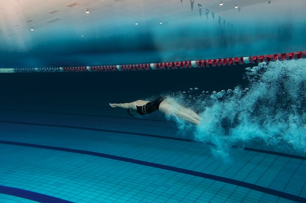 Bezpłatne zdjęcie pływak z pełnym strzałem ze sprzętem w basenie