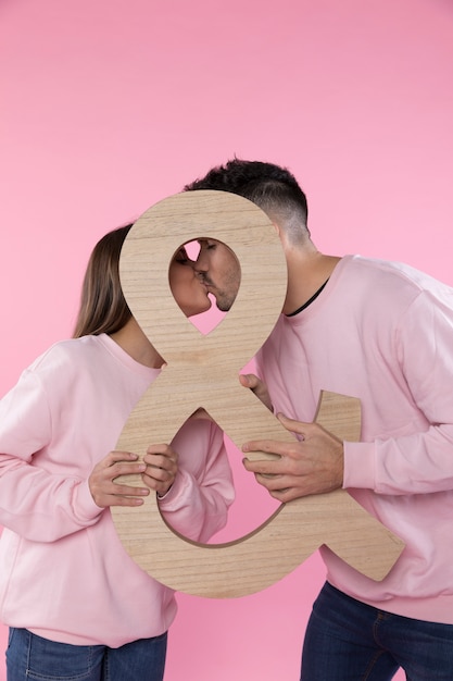 Bezpłatne zdjęcie pocałunek mężczyzny i kobiety, posiadający duży symbol ampersand