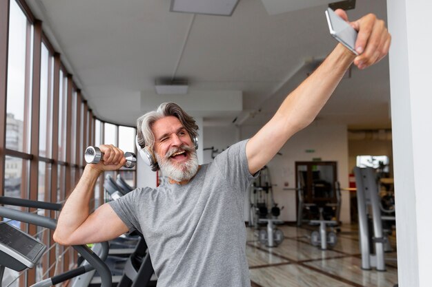 Podekscytowany mężczyzna robi selfie na siłowni