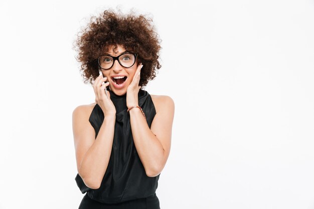 Podekscytowany szczęśliwy bizneswoman rozmawia przez telefon komórkowy w okularach