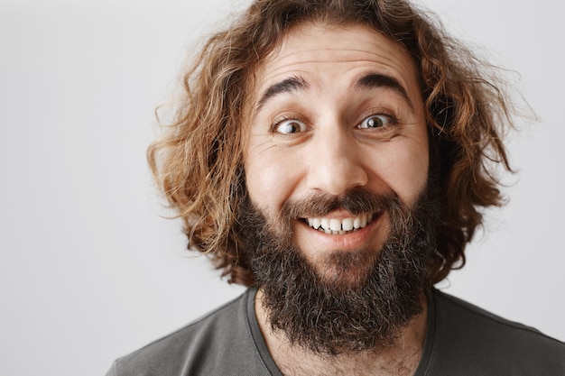 Bezpłatne zdjęcie podekscytowany szczęśliwy człowiek z bliskiego wschodu z brodą wyglądający radośnie, uśmiechnięty entuzjastycznie