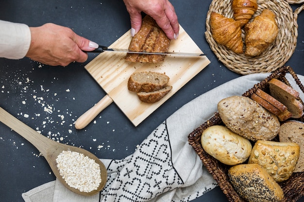 Podniesiony widok dłoni osoby krojenia chleba z nożem