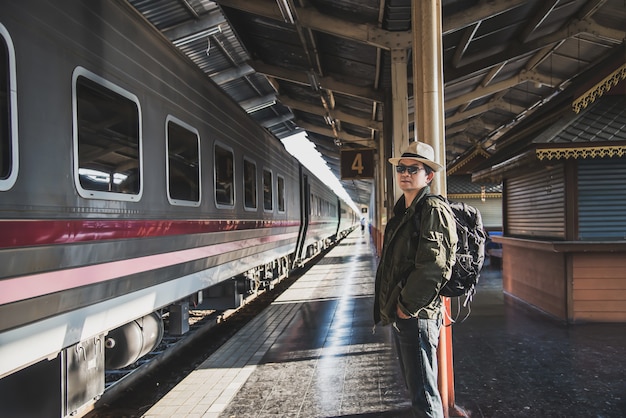 Podróż mężczyzna czekania pociąg przy platformą - ludzie wakacje stylów życia aktywność przy dworca transportu pojęciem