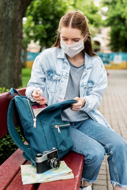 Podróżnik jest ubranym medyczną maskę ma retro kamerę