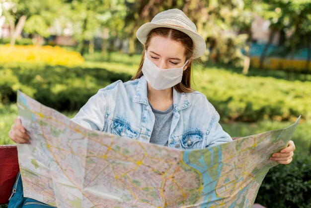 Podróżnik jest ubranym medyczną maskę patrzeje mapę