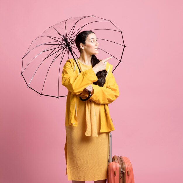 Podróżnik kobieta patrzeje oddalony podczas gdy trzymający parasol