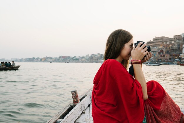 Podróżnik na łodzi robienia zdjęć z rzeki Ganges