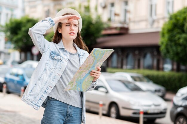 Podróżnik po mieście trzyma mapę i odwraca wzrok