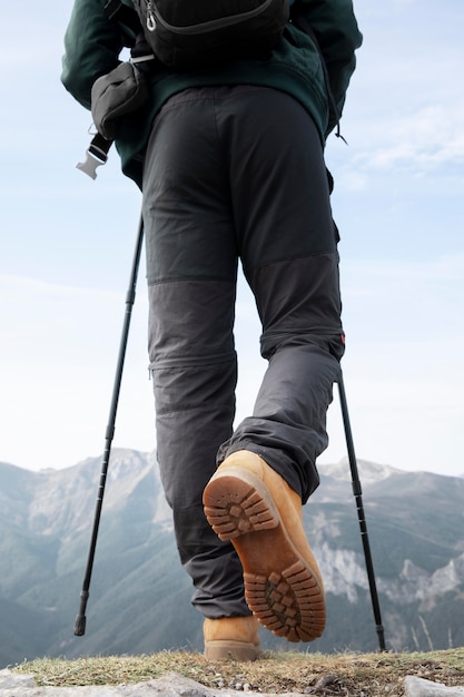Bezpłatne zdjęcie podróżnik wędrujący po górach z niezbędnymi rzeczami w plecaku