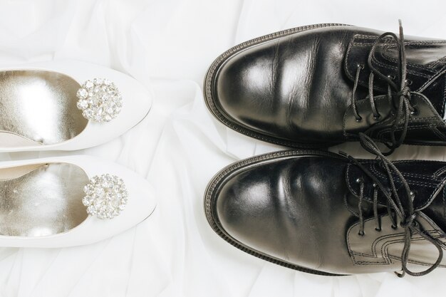 Podwyższony widok białych szpilek i czarnych butów na szaliku