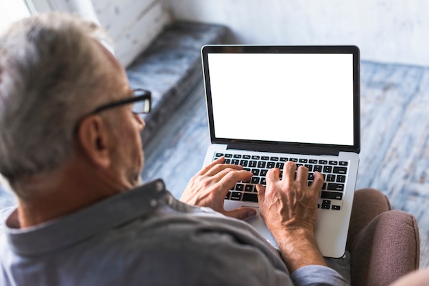 Podwyższony widok mężczyzna używa laptop z białym pustym ekranem