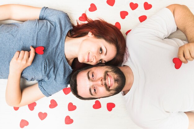 Podwyższony widok szczęśliwa para z czerwonymi sercami na podłoga