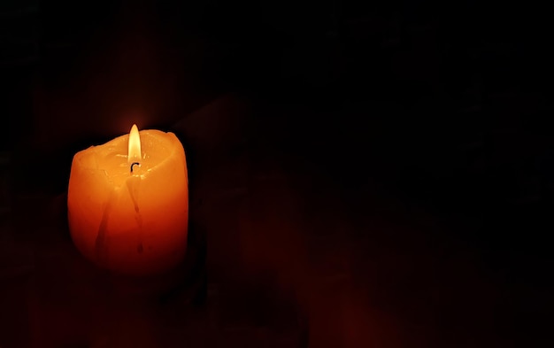 Pogrzebowy płomień świecy przy świecach na ciemnym tle