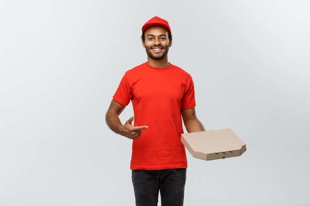 Pojęcie dostawy - Portret przystojny mężczyzna Afroamerykanów dostawy Pizza. Pojedynczo na tle Szarym Studio. Skopiuj miejsce.