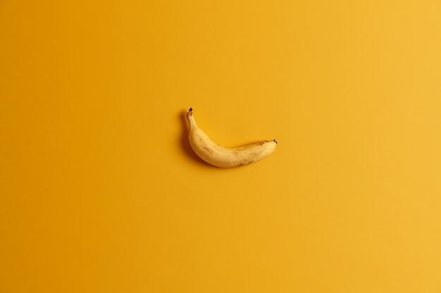 Pojedynczy dojrzałe pyszne żółte banany na białym tle nad tle studio. Dominuje jasny kolor. Owoce tropikalne na smaczną przekąskę. Apetyczny produkt jadalny. Puste miejsce na tekst lub informacje