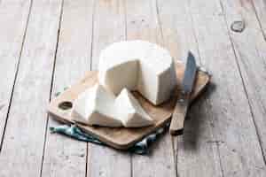 Bezpłatne zdjęcie pokrojony świeży biały ser z mleka krowiego na drewnianym stole
