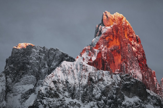 Bezpłatne zdjęcie pokryte śniegiem rocky mountain pod zachmurzonym niebie