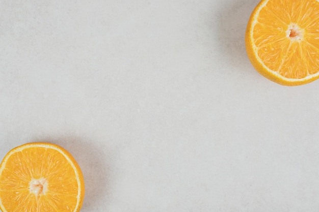 Połówki soczystej pomarańczy na szarej powierzchni