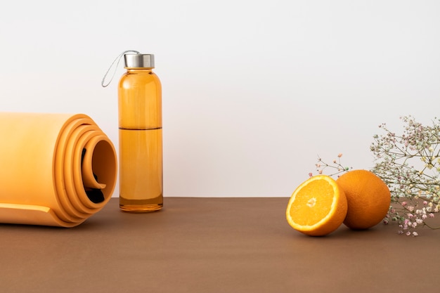 Bezpłatne zdjęcie pomarańczowa mata do jogi i układ butelki z wodą
