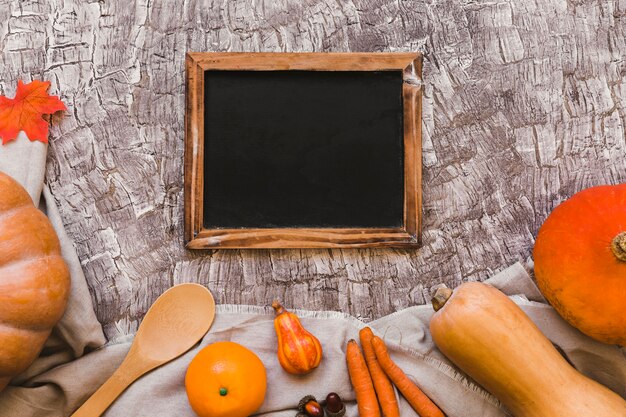 Pomarańczowa owoc i warzywo blisko blackboard