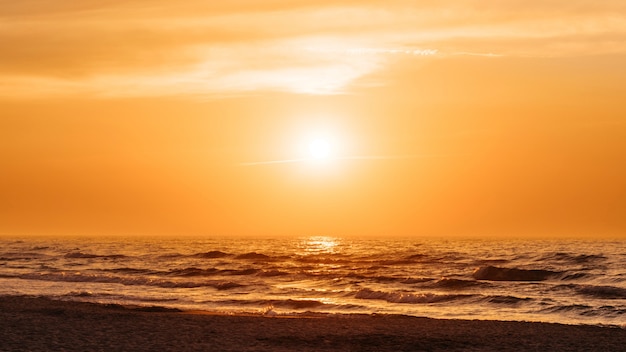 Bezpłatne zdjęcie pomarańczowy zachód słońca na plaży latem