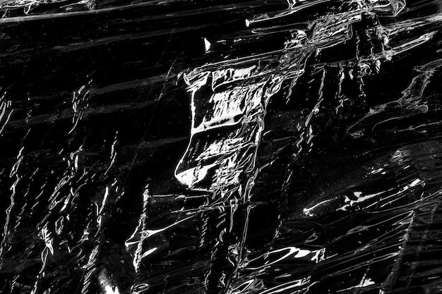 Pomarszczona faktura folii z tworzywa sztucznego na czarnej tapecie