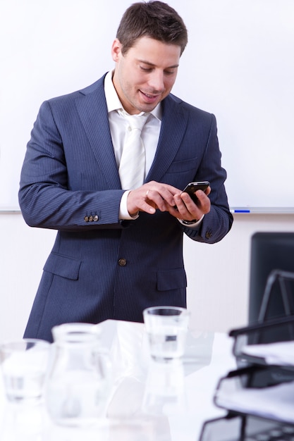 Pomyślny biznesmen używa telefon komórkowego