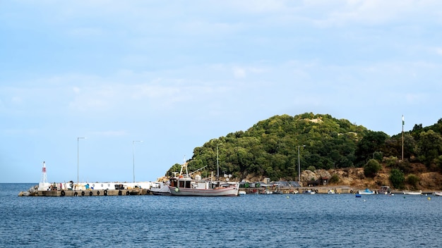 Port Olympiada na wybrzeżu Morza Egejskiego z przycumowanymi łodziami w pobliżu molo