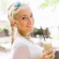 Bezpłatne zdjęcie portret atrakcyjna młoda kobieta trzyma szkło latte macchiato