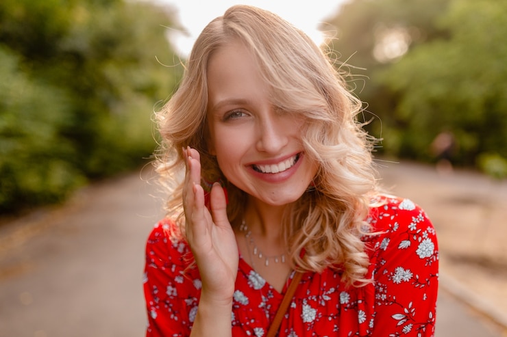 Bezpłatny plik Zdjęcie portret atrakcyjne stylowe blond uśmiechnięta kobieta w czerwonej bluzce strój letniej mody noszenie kolczyków uśmiecha się