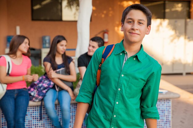 Portret atrakcyjnego nastoletniego chłopca i jego przyjaciół spędzających czas w szkole