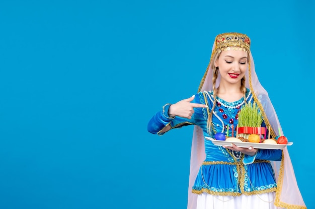 Bezpłatne zdjęcie portret azerskiej kobiety w tradycyjnej sukience z xonca studio strzał niebieskie tło koncepcja novruz tancerz wiosna etniczna