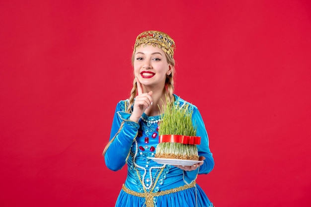 Bezpłatne zdjęcie portret azerskiej kobiety w tradycyjnym stroju z semeni studio strzał czerwone tło wakacje koncepcja wiosna novruz