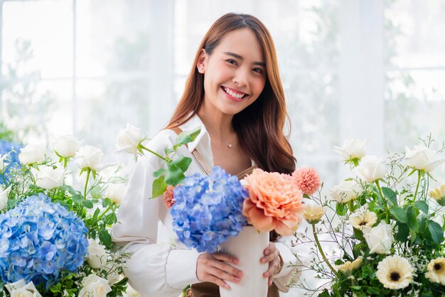 Portret Azja Kobieta kwiaciarnia uśmiech układanie kwiatów w kwiaciarni Projekty kwiatowe sklep szczęście uśmiechnięta młoda dama robi wazon dla klientów przygotowując prace kwiatowe z domu biznesu