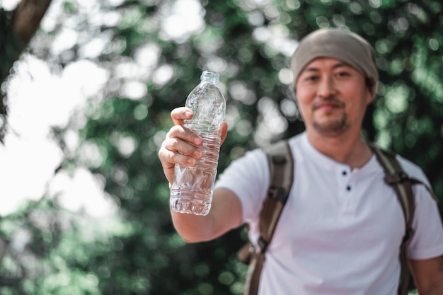 Portret Azjatyckiego Podróżnika Z Plecakiem Pokazującym Butelkę Wody W Lesie Z Kopią Przestrzeni Wakacje Wakacje I Koncepcja Hobby