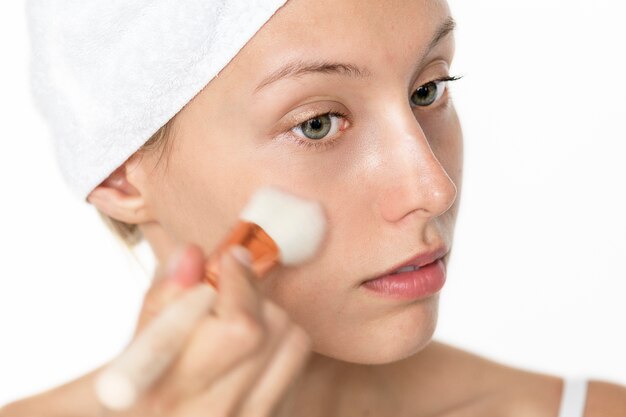 Portret biała kobieta robi jej dziennemu makeup rutynie