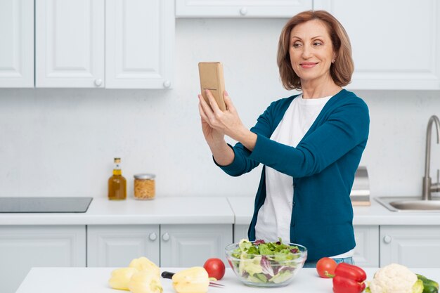Portret bierze selfie w kuchni kobieta